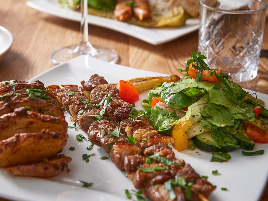 Gegrillte Fleischspieße mit frischem Salat und Kartoffeln